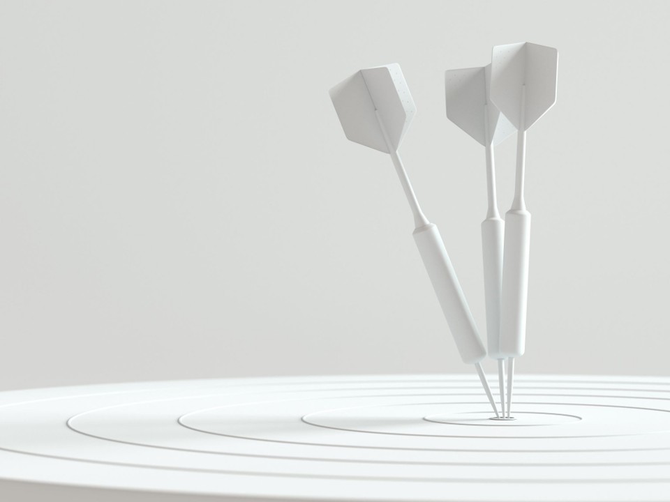 Darts standing in the centre of a board.