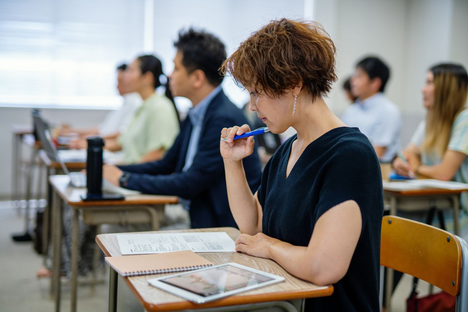 Adults of different ages back in a classroom.